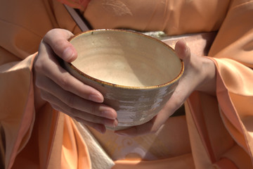 湯のみ茶碗を持つ着物の女性