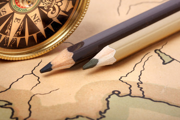 Compass and pencils on old map