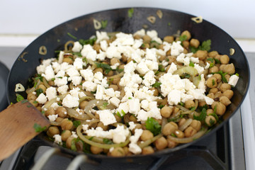 chickpeas and feta cheese in a cast iron pan