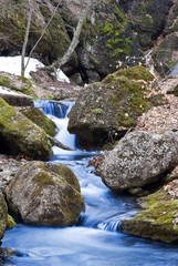 Naklejka na ściany i meble spring brook among a stones