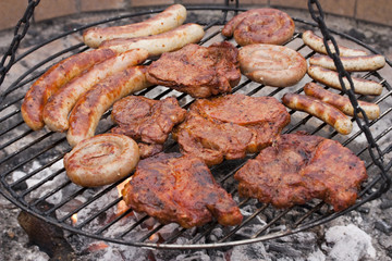 Grillen - Wurst und Fleisch auf glühender Holzkohle