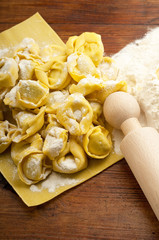 italian homemade tortellini with flour and rolling pin