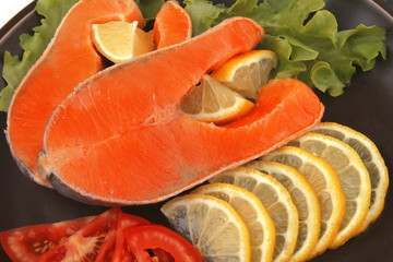 two salmon steak on dark dish