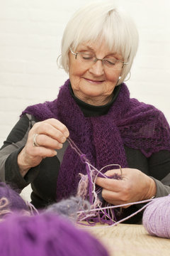 Senior woman sorting out the tangle mess of woollen threads