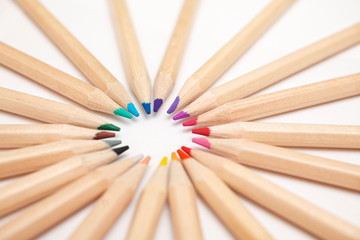 Wooden colouring pencils in a circle on white