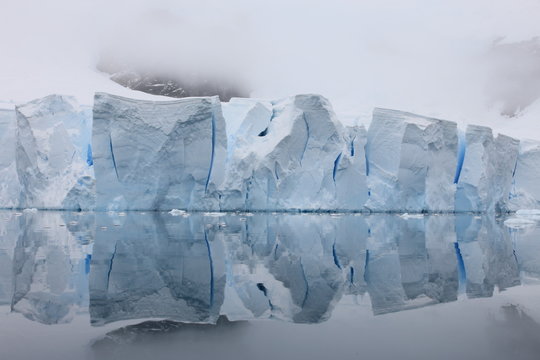 Glacier with reflections on water in Antarctica