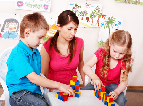 Children preschooler  with wood block  in play room.