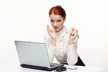 Business woman working on her laptop and drinking coffee.