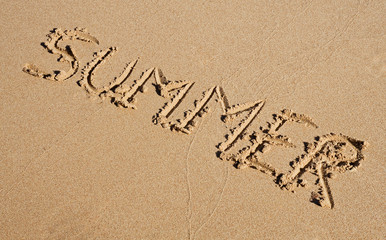 Summer writing on a sandy beach background
