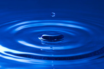 Naklejka na ściany i meble close-up of a droplet, falling in the blue water