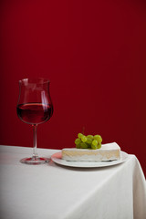 Glas Rotwein und Camembert mit Trauben