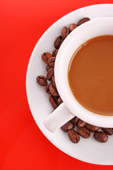 Small white cup of coffee with coffee grain on red background