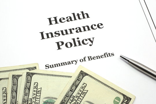 Health Insurance Policy with Pen and Cash