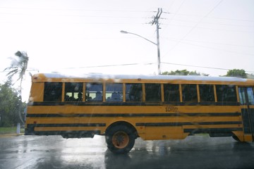 Fototapeta na wymiar Blurry motion road with yellow school bus, hurricane storm rain
