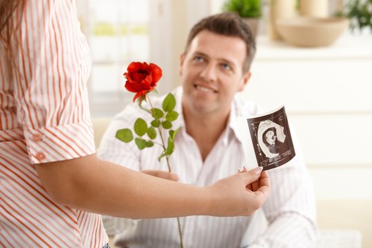 Man giving rose to pregnant woman