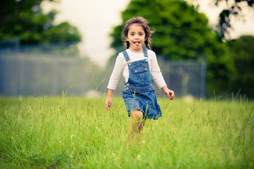 Happy girl walking in a green meadow