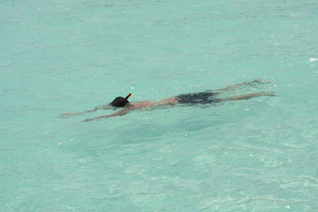 Obraz premium Man snorkeling in crystal clear