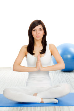 ÊA pretty young woman in a meditative yoga pose