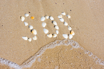 Fototapeta na wymiar SOS in sand on a beach