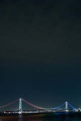 夜空に向かって虹色に輝く明石海峡大橋のイルミネーション