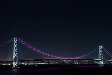 Obraz premium 橋脚の間で青く輝く明石海峡大橋のイルミネーション