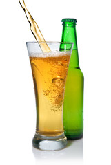 Beer pouring from into glass isolated with bottle on white