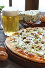 Blue cheese pizza with a glass of beer and some ingredients