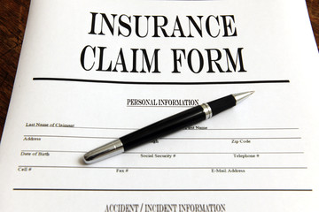 blank insurance claim form and pen