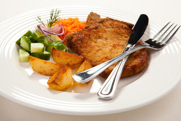 Grilled meat with chips and vegetables