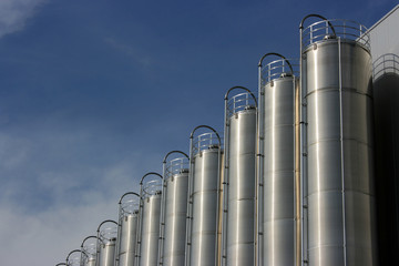 silver industrial silos with blue sky