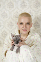 portrait of short hair blond serious woman with cat in bedroom