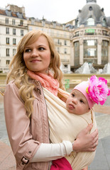 Beautiful young mother with her baby daughter in Paris