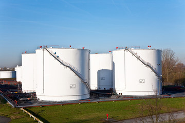 white tanks in tank farm with blue sky