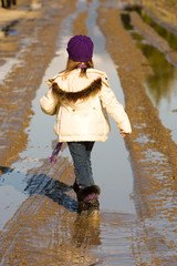 child walking down muddy road