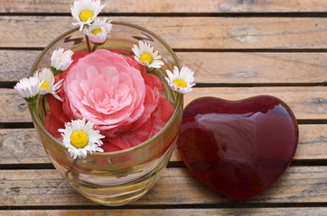 cuore di vetro rosso con margherite e rosa