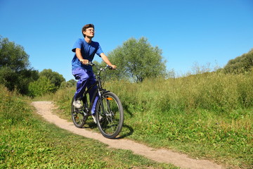 Obraz premium man wearing sporty clothes is riding on bycicle. summer day