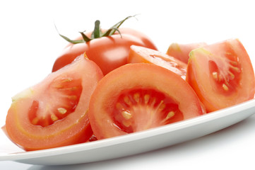 Tomato and tomato slices on white plate