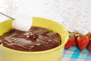 dipping marshmallow in chocolate fondue