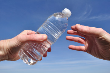 Hand Offering a Bottle of Water