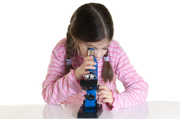 little girl looking with microscope in school laboratory