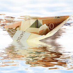petit bateau en billet de 50 euros sur l'eau