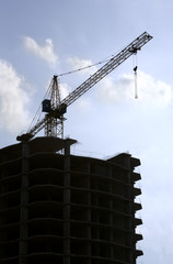 Fototapeta premium Construction works with crane and building under blue sky