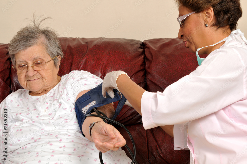 Canvas Prints Mixed raced nurse measuring senior patient's blood pressure