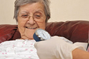 Medical doctore measuring senior patient's blood pressure