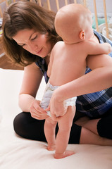 mother changing baby's diaper