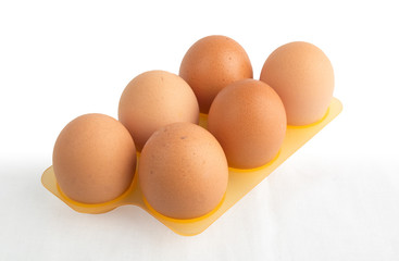 Fresh brown eggs in plastic carton