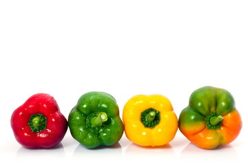 Poivrons colorés alignés sur fond blanc