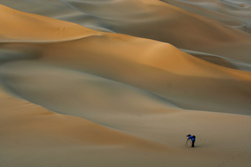 photographer in sand desert - obrazy, fototapety, plakaty
