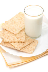 Glass of milk and dish of crackers over table-napkin