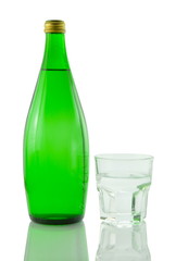 Bottle and glass of mineral water reflected on white background